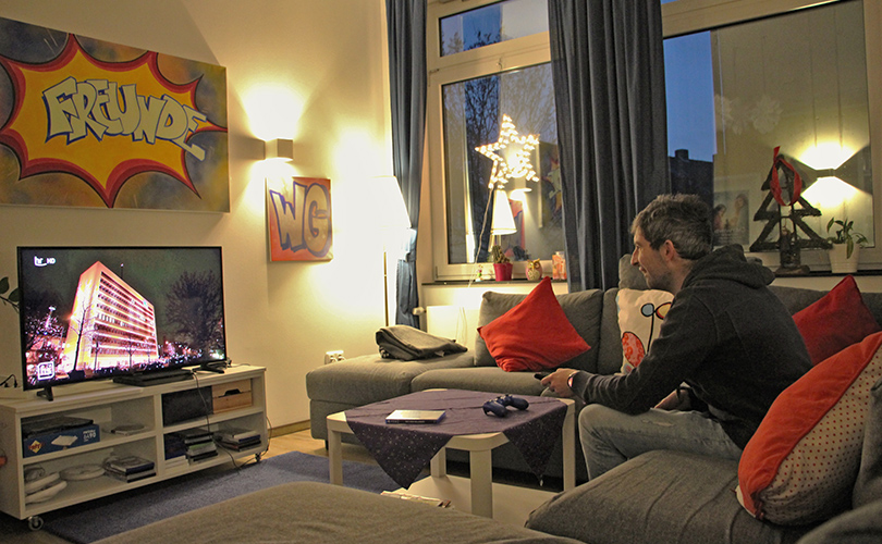 Ein Bewohner schaut Fernsehen in seinem Zimmer.